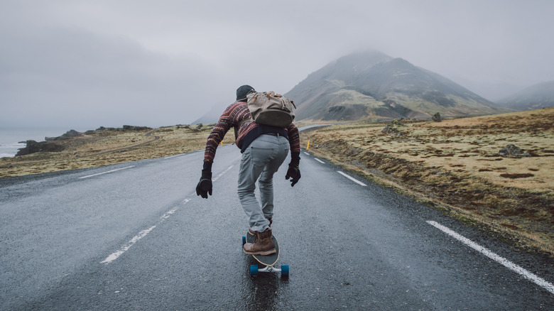 Man longboarding down scenic road