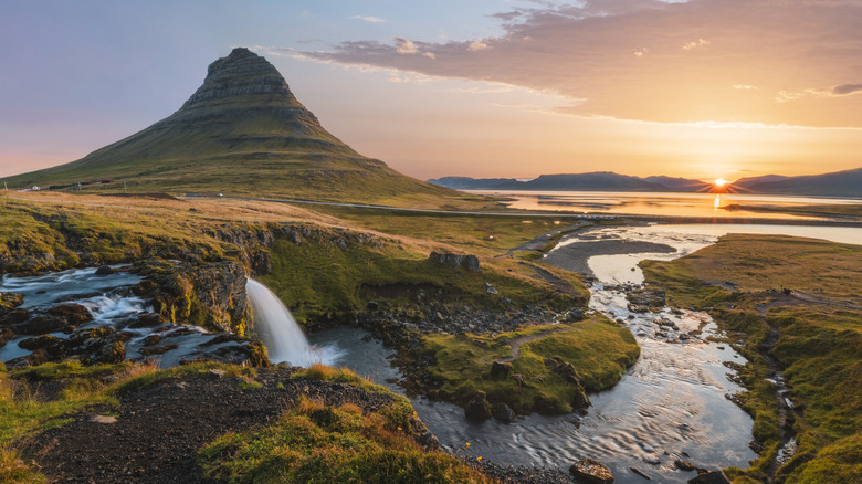 conical hill behind mossy landscape with waterfall