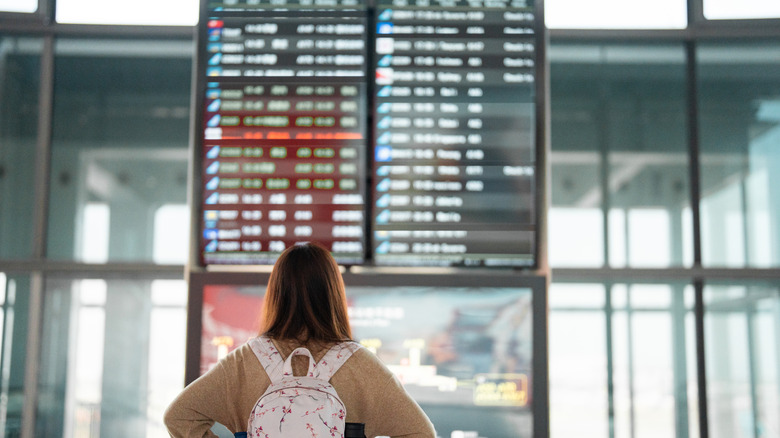 A woman looking at flight times in the airport