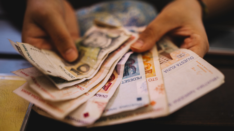 Two hands hold Croatian kuna, the former currency