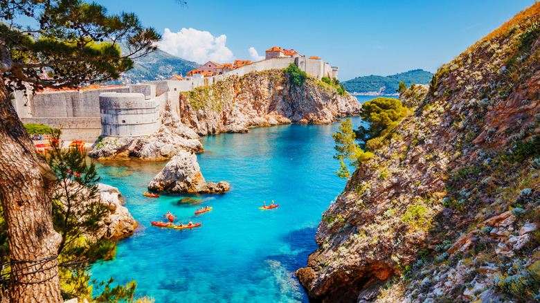 Kayakers paddle in blue waters next to Dubrovnik, Croatia