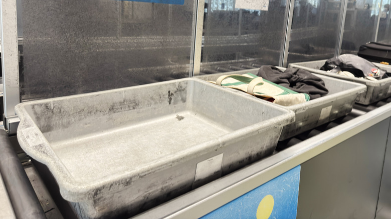 Full and empty TSA bins on a security belt