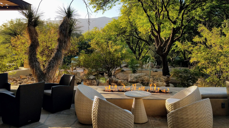 A patio with wicker chairs and a firepit at Miraval Resort Arizona.