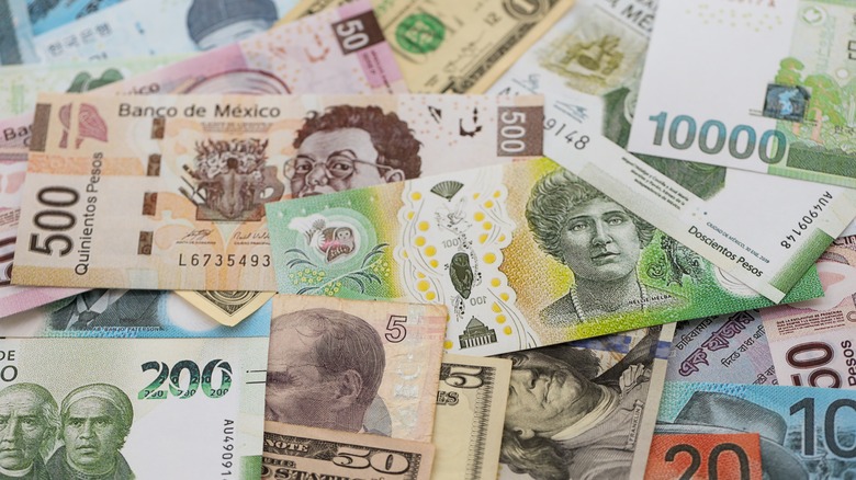 Piles of international currency overlap on a flat surface