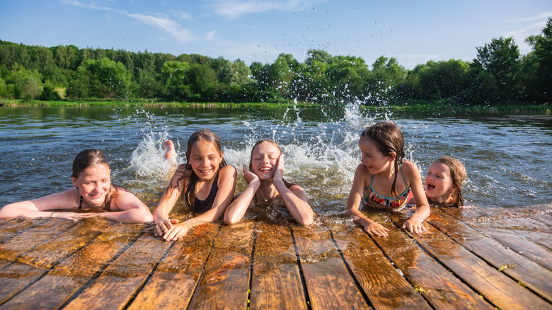 Smiling children splashing in lake