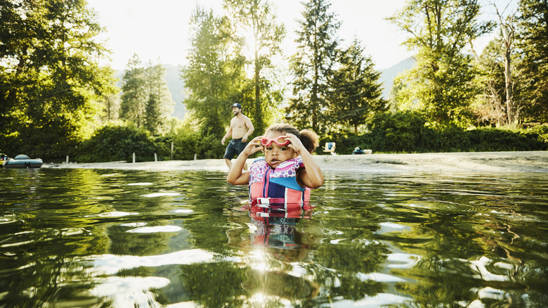 Child wearing life jacket in a river