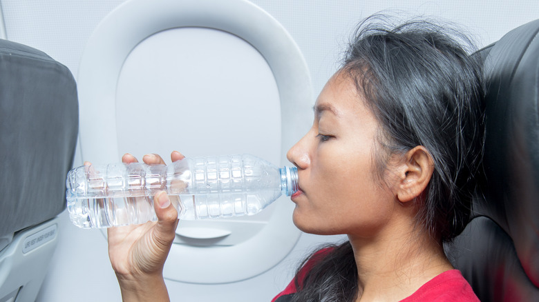 woman drinking water on plane
