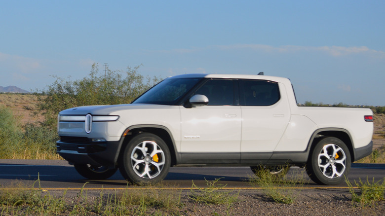 A Rivian R1T white electric truck on the road