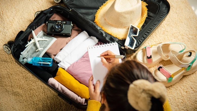 Woman writing on baggage