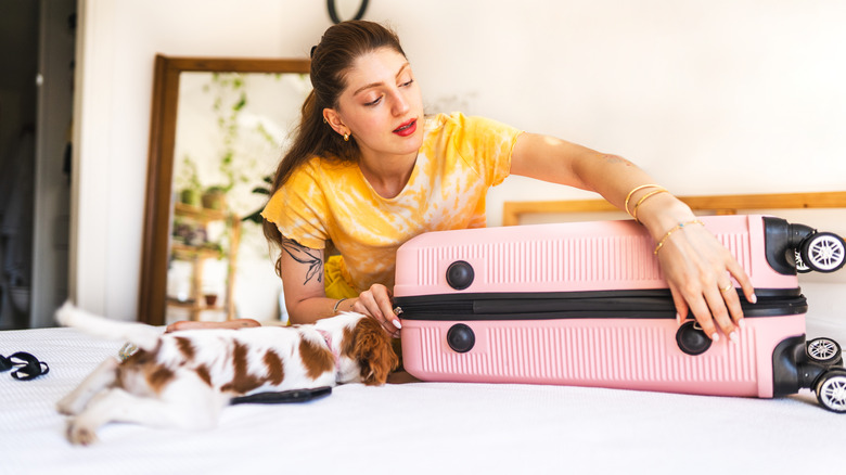 Woman closing a suitcase
