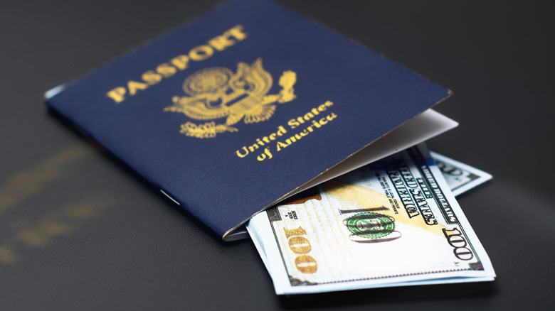 US passport stuffed with several 100 dollar bills