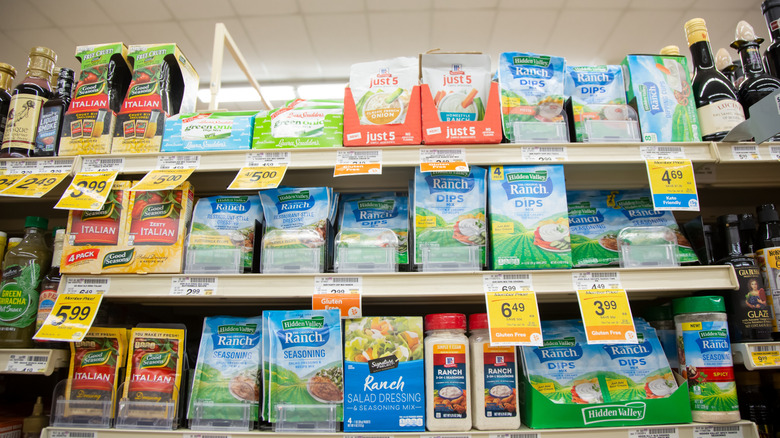 Packets of ranch seasoning on supermarket shelves.