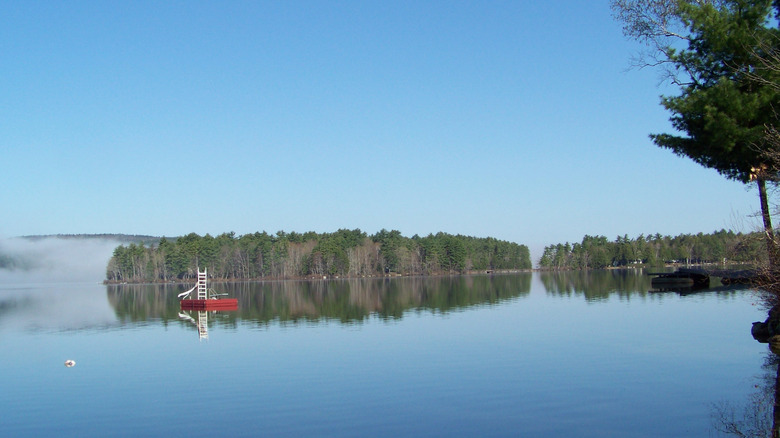 a reflective blue lake with a small red floating dock