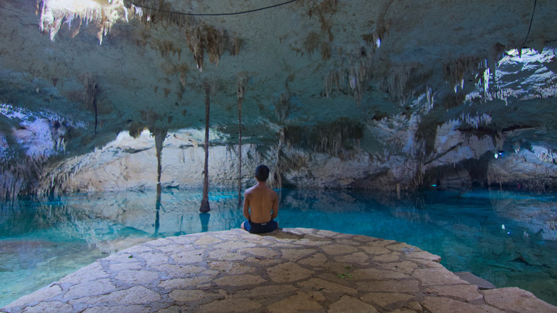 A man observes Cenote Taak Bi Hah near Tulum, Mexico