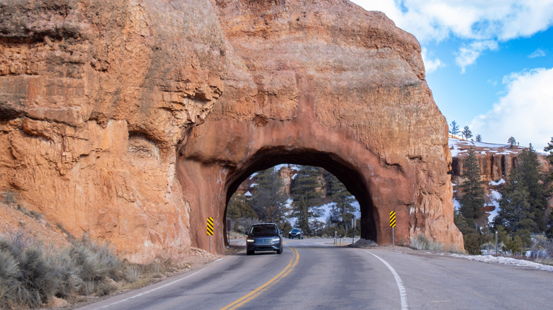 Cars driving through natural rock tunnel in Bryce Canyon