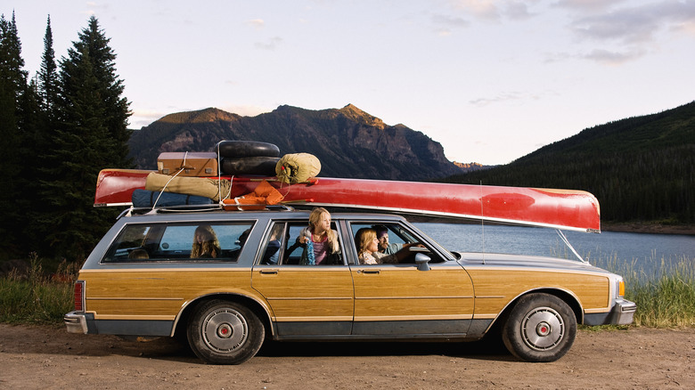 Family with car packed for road trip
