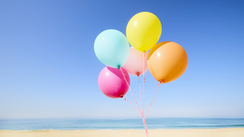 a bunch of balloons on a beach