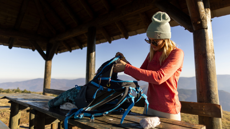 woman repacking hiking backpack