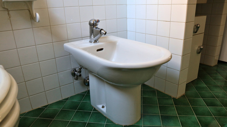 Bidet in a bathroom in Italy. Generic retro style Italian bathroom with ceramic bidet washing basin.