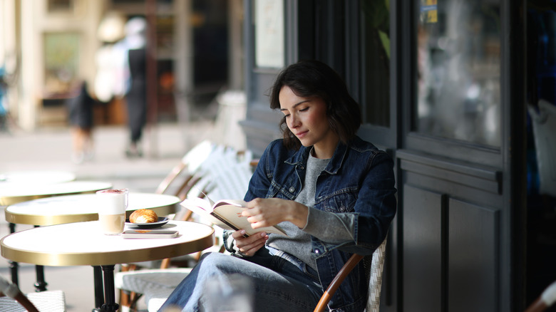 Woman reading book at a café