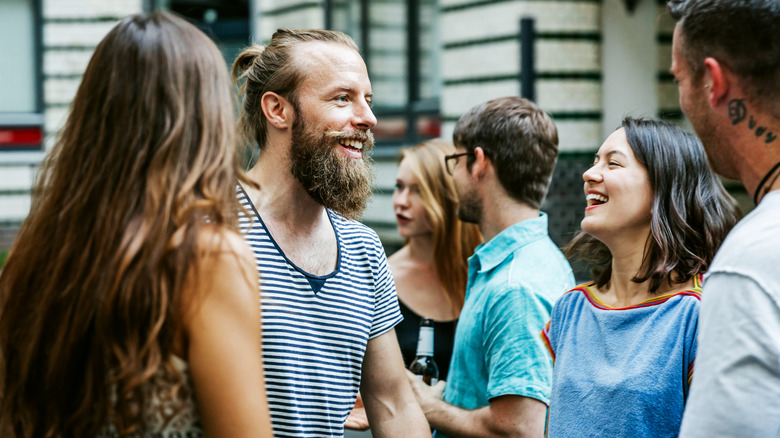 a group of people chatting and smiling outside