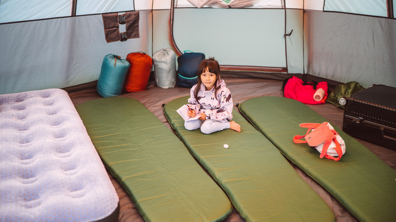 Cute kid with many sleeping pads