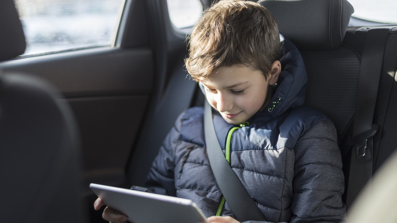 Boy in car with tablet