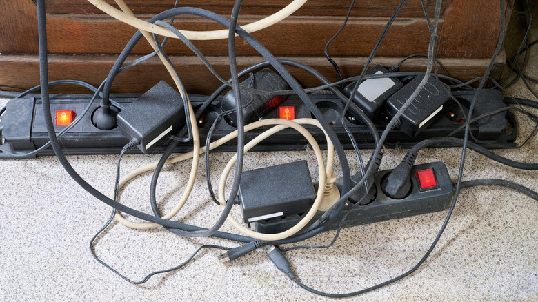 A jumble of messy cords around a power strip.