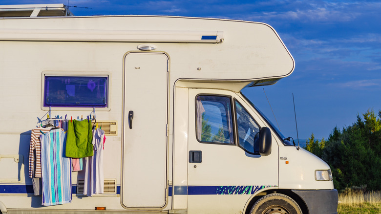 A campervan with clothes hanging on the outside to dry.