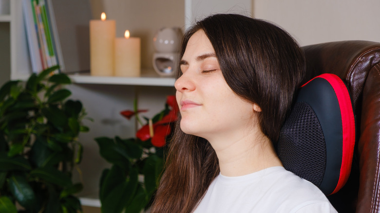 Woman sitting in chair with massage pillow