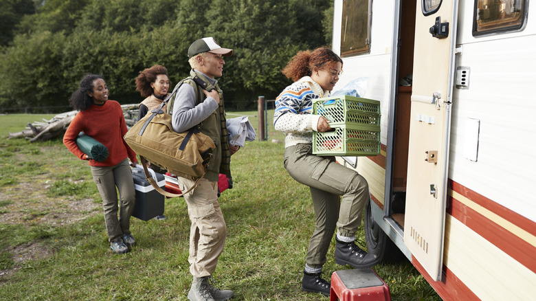 Family carrying belongings onto RV