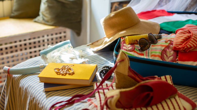 An unorganized pile of travel items in a suitcase