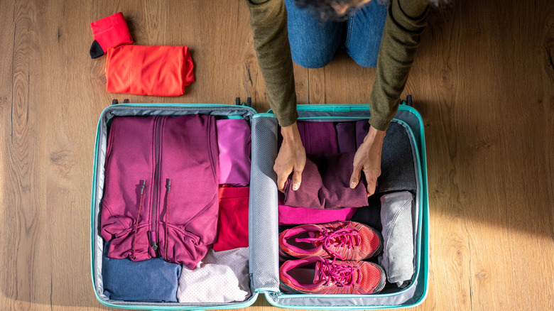 Open suitcase with clothes and shoes