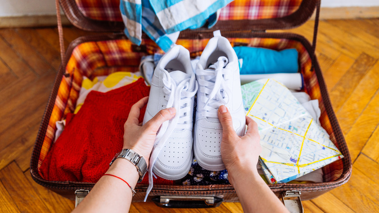 Shoes going into an open suitcase