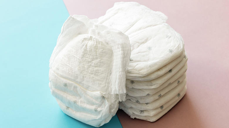 Diapers in front of a pink and blue background