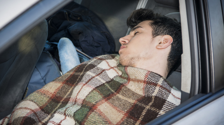 man sleeping in car