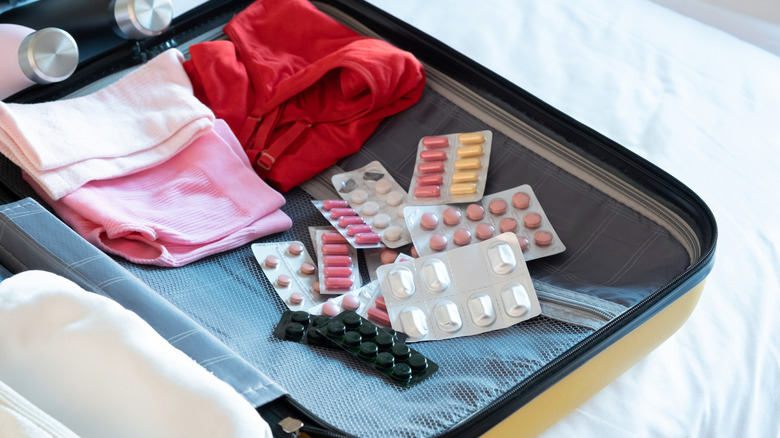 Assorted medicine tablets inside suitcase