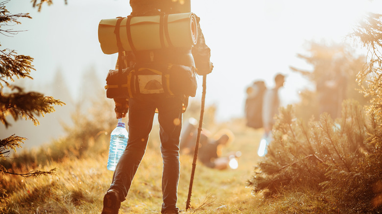 Hiker walking toward group with gear