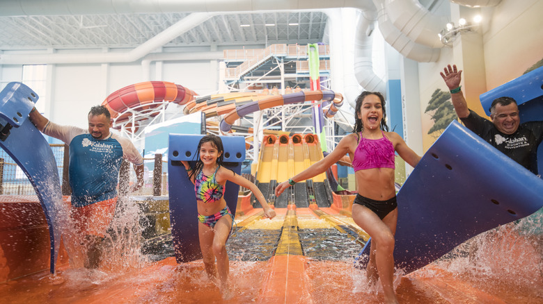 Kids and adults playing at the Kalahari indoor park's waterslide.