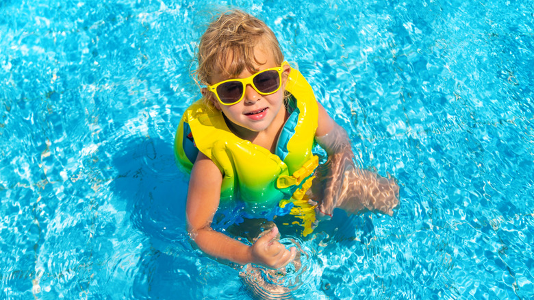 Child wearing a life jacket in the pool