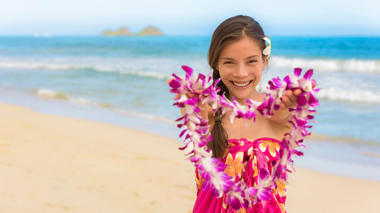 a woman presenting a flower lei