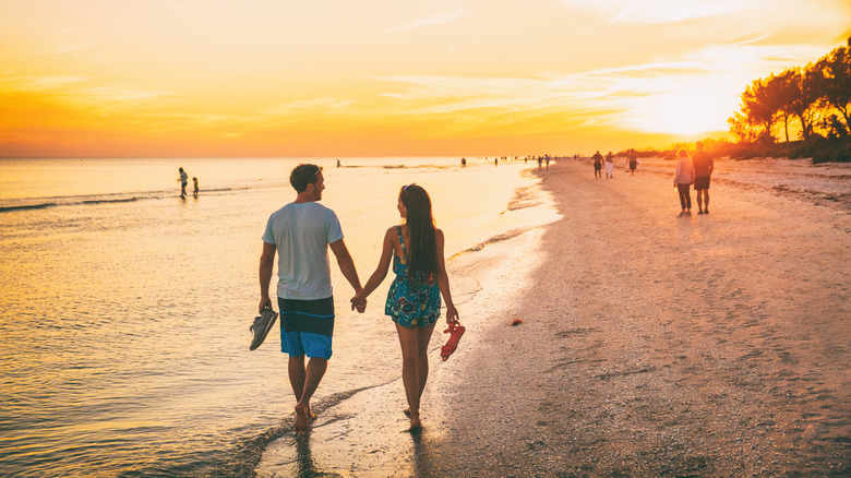 Couple walking along Sanibel Island shoreline