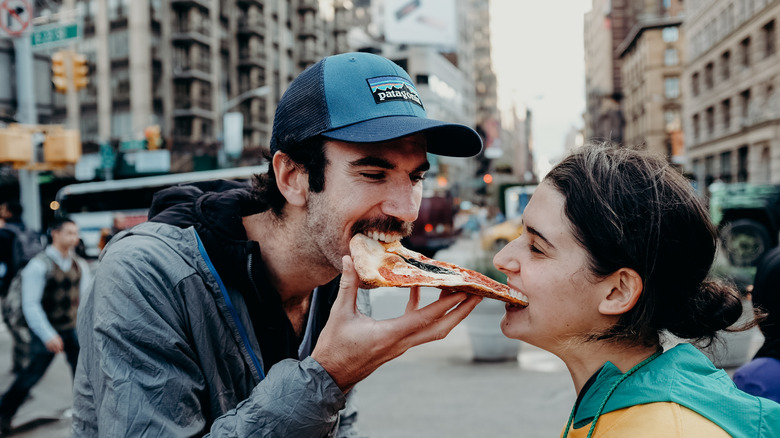 Couple sharing a slice of New York pizza