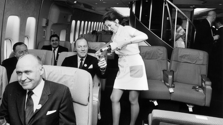 flight attendant pouring Champagne