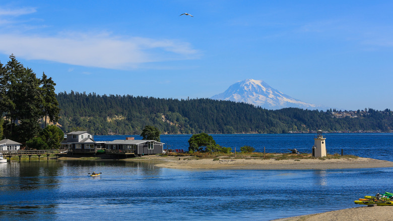 the Gig Harbor Lighthouse and a kayaker in Gig Harbor Bay with Mount Rainier in the background in Washington