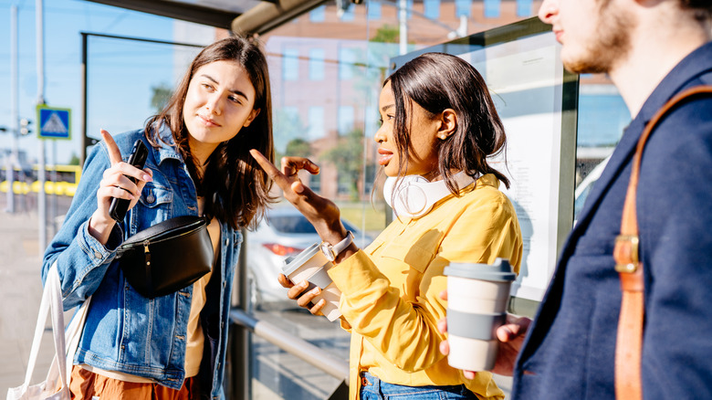 two young women communicating to each other with hand gestures