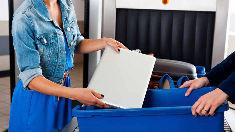 Woman holding laptop at airport security