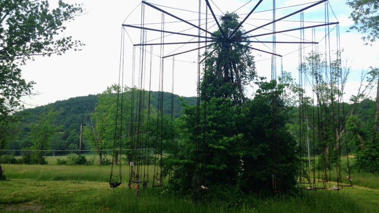 an abandoned swing ride at Lake Shawnee Abandoned Amusement Park in West Virginia