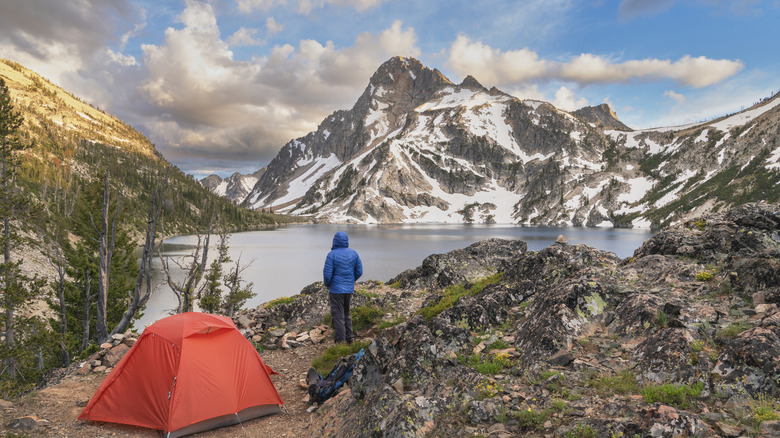 camper looking out at a lake and mountains