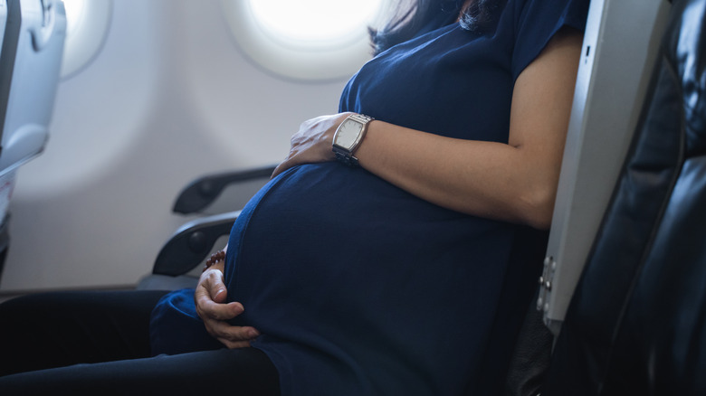 pregnant person sitting on plane